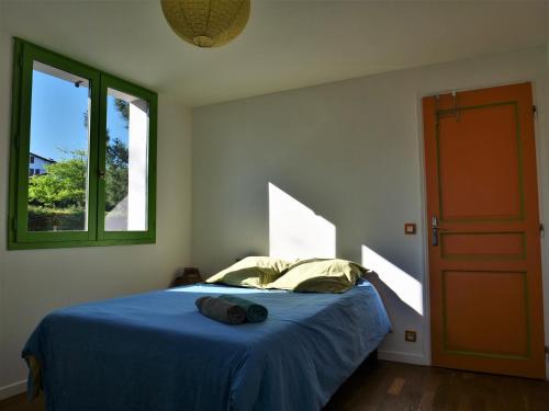 a bedroom with a blue bed and a window at Izpi Urdin Holistic surfhouse in Saint-Jean-de-Luz