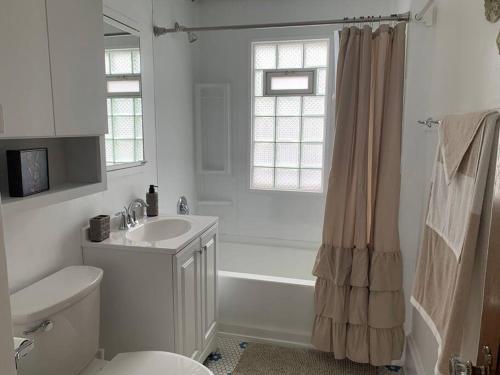 a white bathroom with a sink and a toilet at Nice 1 BR Apt, WIFI & Office, Near State Fair in West Allis