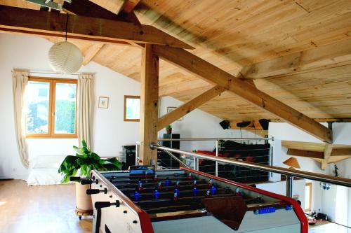 Habitación con mesa de ping pong y techos de madera. en Izpi Urdin Holistic surfhouse, en San Juan de Luz