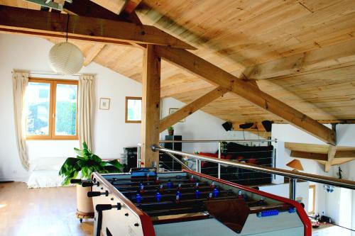 Cette chambre dispose d'une table de ping-pong et de plafonds en bois. dans l'établissement Izpi Urdin Holistic surfhouse, à Saint-Jean-de-Luz