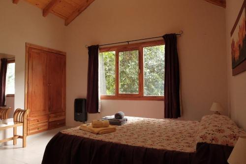 a bedroom with a bed with a window at Cabañas Mijos in El Bolsón