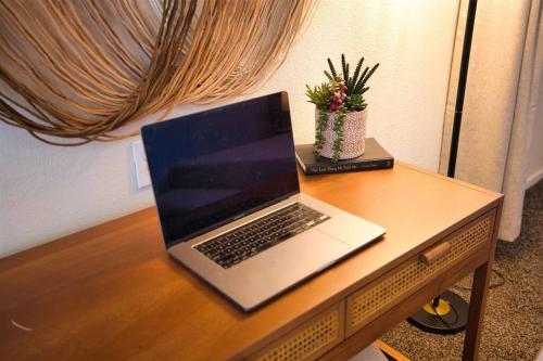 a laptop computer sitting on top of a wooden desk at The Scott Pad - Remodeled space, large pool, centrally located in the heart of Scottsdale! in Scottsdale