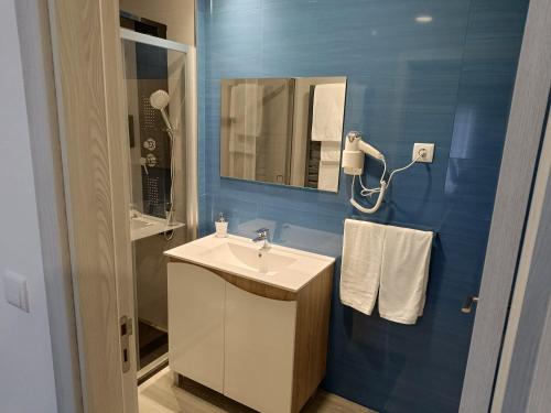 a bathroom with a sink and a mirror at Garden House Fundão - Suíte 103 com varanda in Fundão