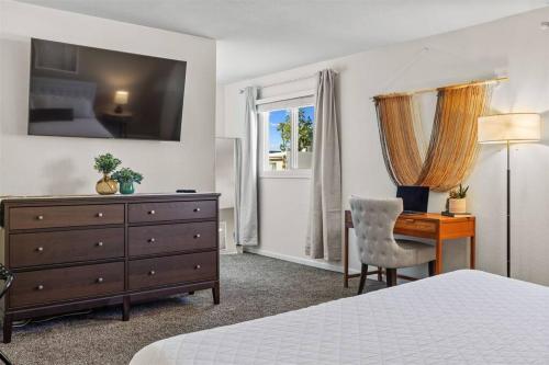 a bedroom with a bed and a desk and a dresser at The Scott Pad - Remodeled space, large pool, centrally located in the heart of Scottsdale! in Scottsdale
