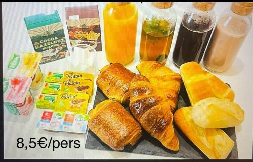 a table topped with pastries and oranges and orange juice at Faranel in Berlaimont