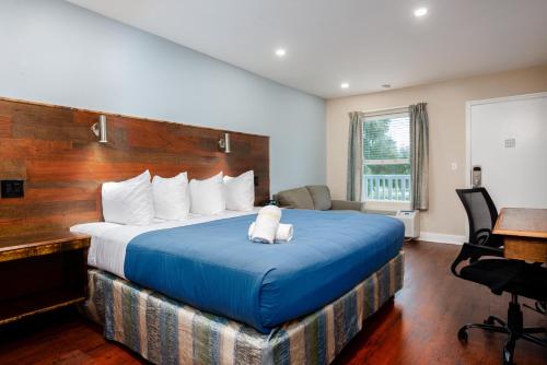 a hotel room with a large bed with blue sheets at Southern Oaks Inn - Saint Augustine in Saint Augustine