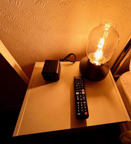 a lamp and a remote control on a table at 50 Etherley Lane in Bishop Auckland