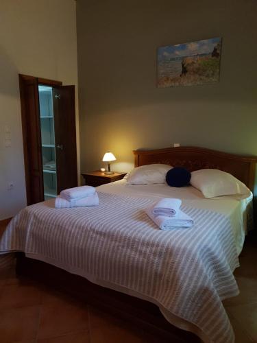 a bedroom with a large bed with towels on it at Stone Edge Homestead in Agios Leon