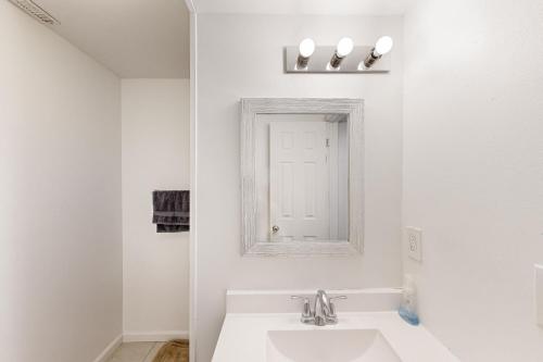 a white bathroom with a sink and a mirror at Garden Cottage in Rapid City