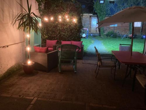 a patio with a table and chairs and lights at Hostal Argentina Osorno in Osorno