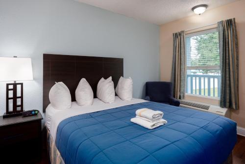 a hotel room with a blue bed with towels on it at Southern Oaks Inn - Saint Augustine in Saint Augustine