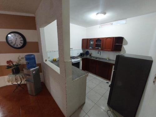 a small kitchen with a clock on the wall at Departamentos de la Costa3 in Machala