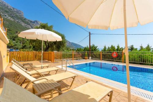 basen z krzesłami i parasolem obok basenu w obiekcie Corfu Sea View Villa - Eros w mieście Barbati