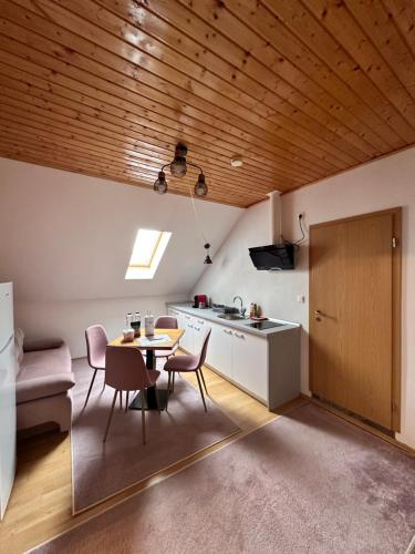 een keuken met een tafel en stoelen in een kamer bij Red Family Apartments in Păltiniş