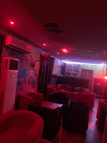 um quarto com luzes vermelhas e cadeiras vermelhas em Classic suites chillout 