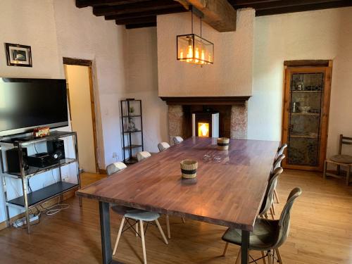 Cette chambre comprend une grande table en bois et une télévision. dans l'établissement Maison de caractère avec jacuzzi entre mer et montagne à Espira de Conflent, à Espira-de-Conflent