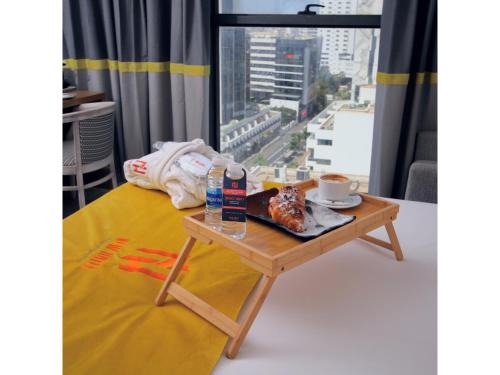 een tafel met een dienblad met eten op een bed met een raam bij New Hotel Piscine Wellness & Spa in Casablanca