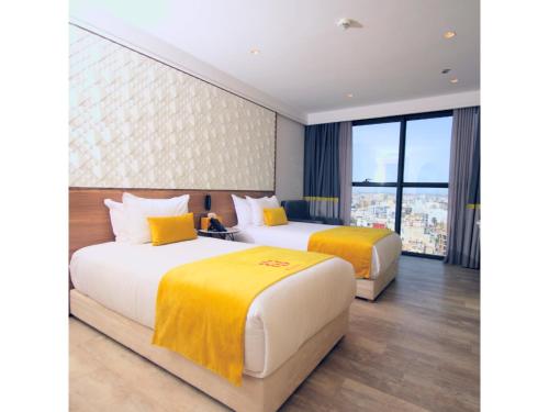 two beds in a hotel room with a window at New Hotel Piscine Wellness & Spa in Casablanca