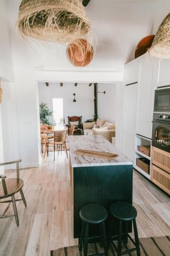 a kitchen and living room with a table and chairs at Casa Vó Briata in Mértola