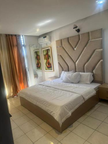 a bedroom with a large bed with a large headboard at Merry Villa in Lagos