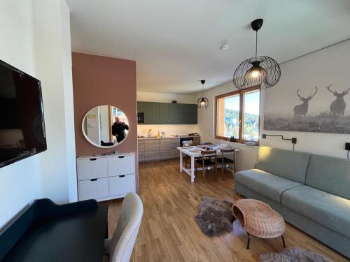 a living room with a couch and a dining room at AlmApp Nassfeld in Sonnenalpe Nassfeld