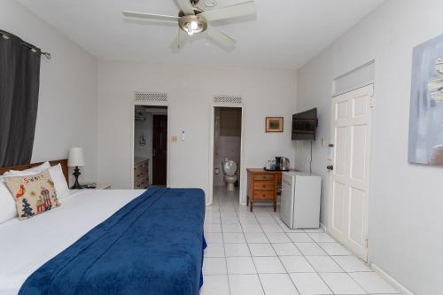 a bedroom with a bed and a ceiling fan at Caribic House in Montego Bay