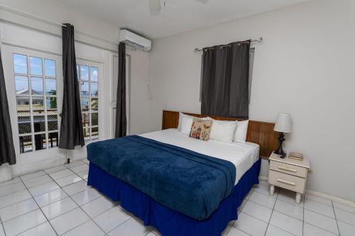 a bedroom with a large bed with a blue blanket at Caribic House in Montego Bay