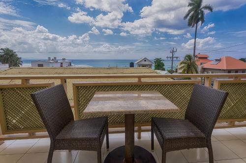 a table and chairs on a balcony with the ocean at Caribic House in Montego Bay