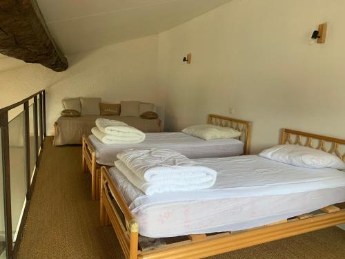 3 camas están alineadas en una habitación en Maison de caractère avec jacuzzi entre mer et montagne à Espira de Conflent en Espira-de-Conflent