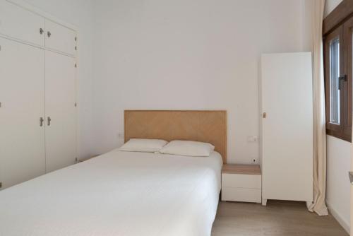 sypialnia z dużym białym łóżkiem z białymi szafkami w obiekcie Apartamento Centro Deluxe w Kadyksie
