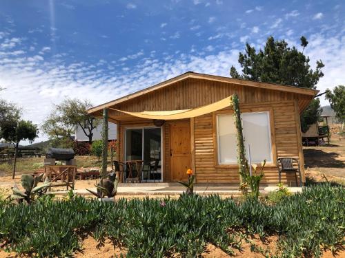 a small wooden cabin with a table and a grill at Los Quillayes in Melipilla