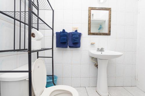 a white bathroom with a toilet and a sink at Caribic House in Montego Bay