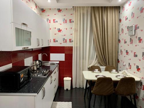 Il comprend une cuisine équipée d'une cuisinière et d'une table avec des chaises. dans l'établissement Brothers, à Tbilissi