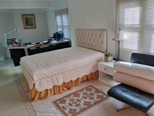 1 dormitorio con cama, escritorio y sofá en Casa com piscina, churrasqueira, fogão à lenha. SUL DE MINAS GERAIS, en Itajubá