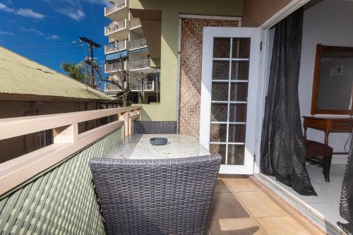 a balcony with a table and a chair on a building at Caribic House in Montego Bay
