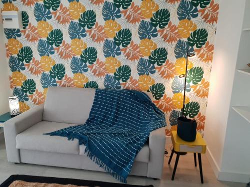 - un salon avec un canapé et un papier peint à fleurs dans l'établissement RAVISSANT Studio MARINA GOSIER, au Gosier
