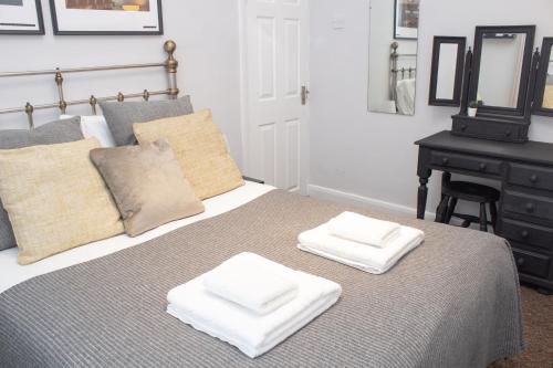 a bedroom with a bed with two white towels on it at Cosy 3 bed home with garden - near to uni, restaurants & bars in Hull