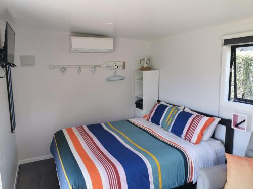 Кровать или кровати в номере Pacific Bay HQ - Tutukākā Holiday Unit