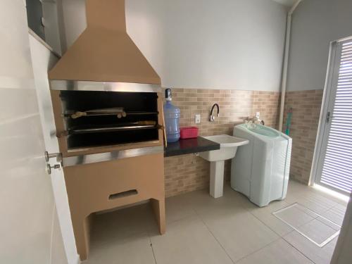 een kleine keuken met een wastafel en een fornuis bij Residencial Belaju 02 in Bombinhas