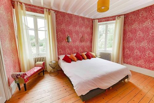 a bedroom with a large bed with red walls and windows at Maison Nelson in Villecerf