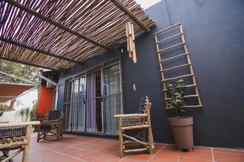 a porch with a ladder and chairs and a blue wall at I Stay @ De 22 On Vintage in Windhoek