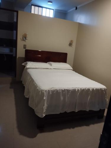 a bedroom with a large bed with white sheets at Amazon deluxe in Jaén