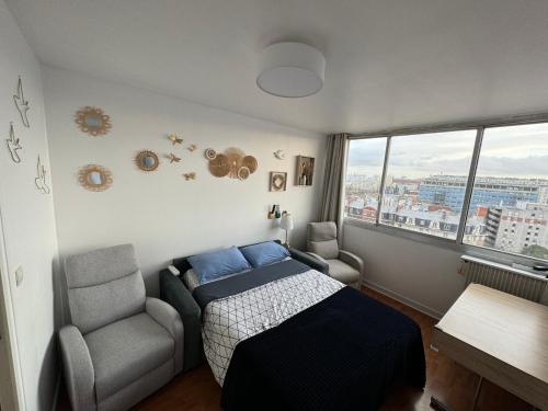 a bedroom with a bed and a chair and a window at Private room in a shared apartment - Metro 7 and Tramway T3a in Paris