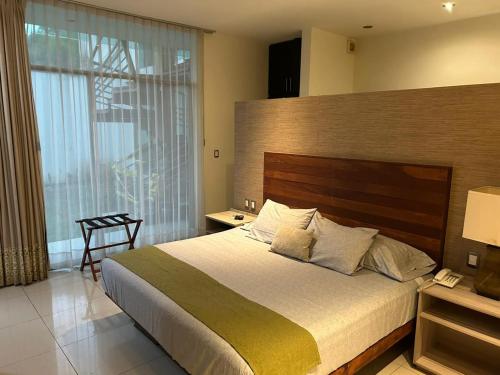 1 dormitorio con cama grande y ventana grande en Amoe en Boca del Río