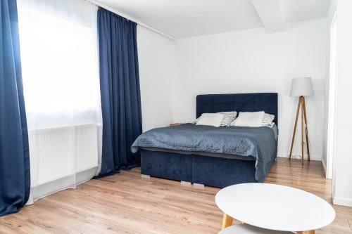 a bedroom with a bed and a table at Hostel & Apartments Kołobrzeg in Kołobrzeg