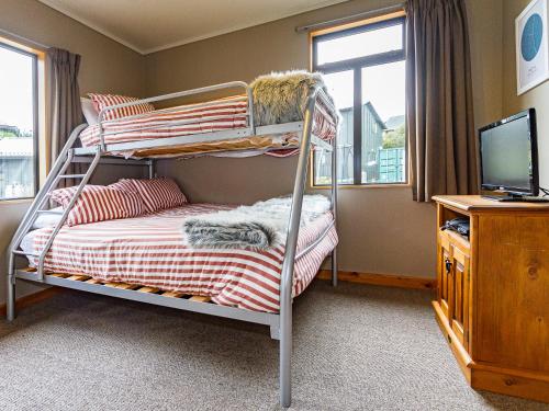 a bedroom with two bunk beds and a television at Ski Country Chalet - Ohakune Holiday Home in Ohakune