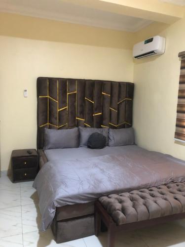 a bed with a large headboard in a bedroom at Furnished 2bedroom Apt in Wuye in Wupa