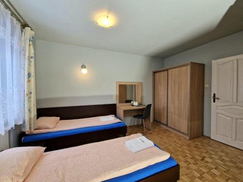 a hotel room with two beds and a desk at Bolko in Stronie Śląskie