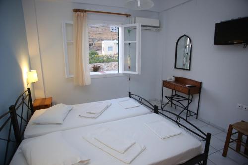2 camas en una habitación con ventana en Palaiologos, en Posidhonía