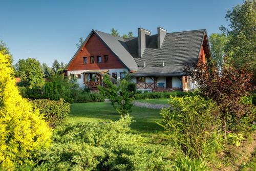 a house with a gambrel roof on a yard at Villa Bezycer in Gowidlino